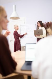 Pr&auml;sentation im Team von i-Hotel Services, Diskussion vor einem Flipchart.